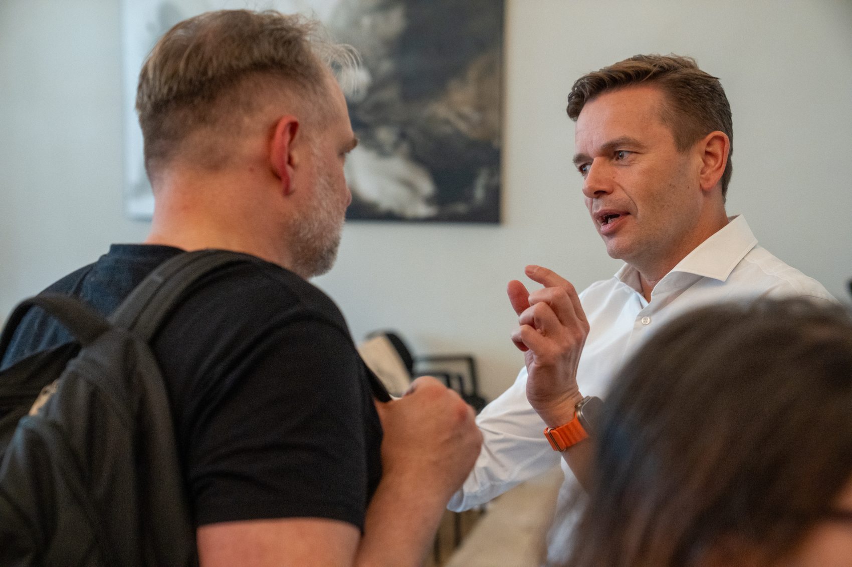 Maxim Korseko advising a business leader in conversation at an event